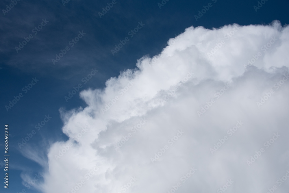 Obraz premium Puffy white clouds on a blue-sky day, as a nature background
