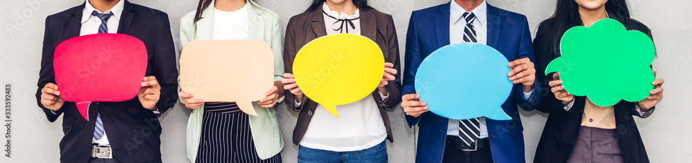 Group of business people holding a empty copyspace speech bubble icon while standing against grey background - obrazy, fototapety, plakaty 