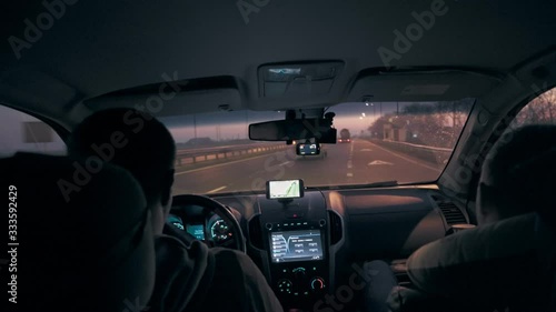 The driver and passenger drive in the car on the highway in the early morning