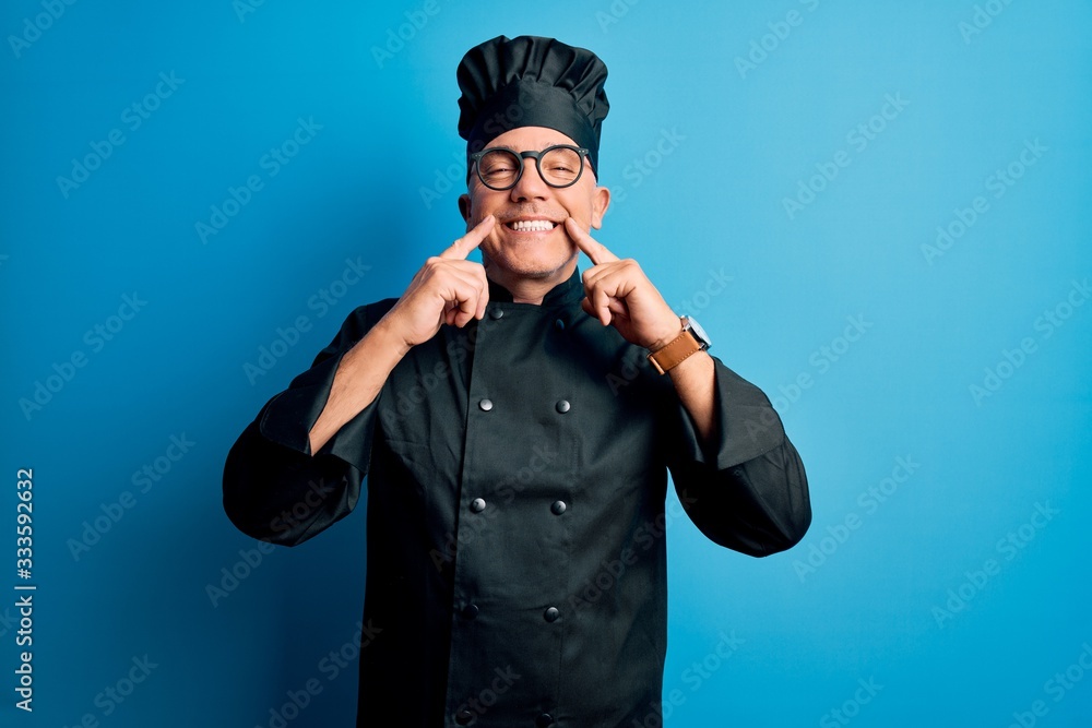 Middle age handsome grey-haired chef man wearing cooker uniform and hat Smiling with open mouth, fingers pointing and forcing cheerful smile Middle age handsome grey-haired chef man wearing cooker uniform and hat Smiling with open mouth, fingers pointing and forcing cheerful smile
