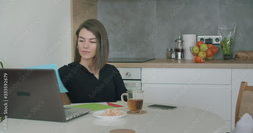 Woman working with papers sitting in kitchen at home. Woman working with papers sitting in kitchen at home.