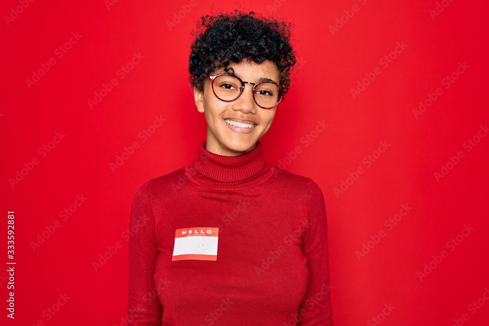 Young beautiful african american afro woman using sticker with presentation message with a happy face standing and smiling with a confident smile showing teeth Young beautiful african american afro woman using sticker with presentation message with a happy face standing and smiling with a confident smile showing teeth