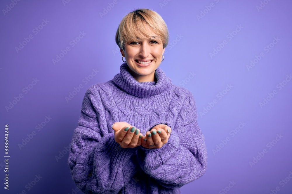 Young blonde woman with short hair wearing winter turtleneck sweater over purple background Smiling with hands palms together receiving or giving gesture. Hold and protection Young blonde woman with short hair wearing winter turtleneck sweater over purple background Smiling with hands palms together receiving or giving gesture. Hold and protection