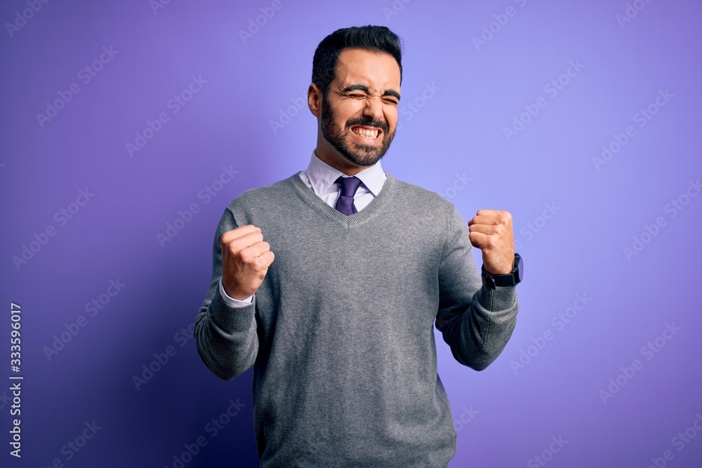 Handsome businessman with beard wearing casual tie standing over purple background excited for success with arms raised and eyes closed celebrating victory smiling. Winner concept. Handsome businessman with beard wearing casual tie standing over purple background excited for success with arms raised and eyes closed celebrating victory smiling. Winner concept.