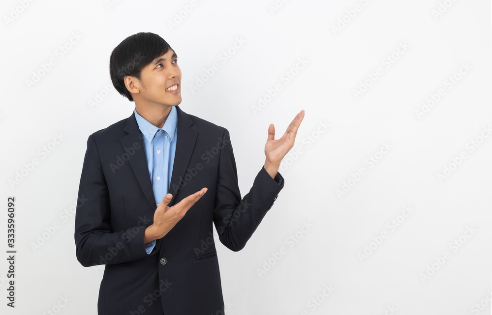 Young asian business man with blue shirt pointing to the side with a hand to present a product or an idea isolated on white background. Young asian business man with blue shirt pointing to the side with a hand to present a product or an idea isolated on white background.