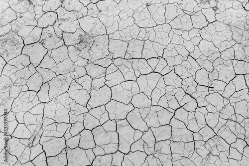 Gray dry soil ground cracks background texture in drought, Top view
