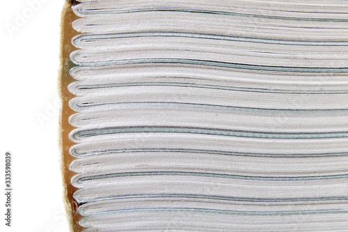 Obraz na plátně A book lying horizontal showing the type of book binding where pages of the book are folded into section and attached together onto the cover using a strong glue