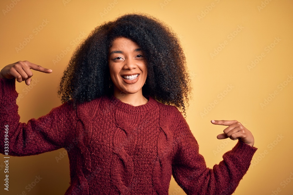 Young beautiful african american woman with afro hair standing over yellow isolated background looking confident with smile on face, pointing oneself with fingers proud and happy. Young beautiful african american woman with afro hair standing over yellow isolated background looking confident with smile on face, pointing oneself with fingers proud and happy.