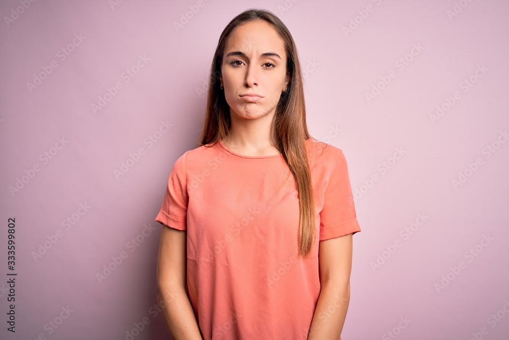 Obraz premium Young beautiful woman wearing casual t-shirt standing over isolated pink background depressed and worry for distress, crying angry and afraid. Sad expression.