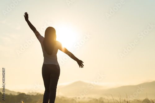 Silhouette of happy woman spreading arms and watching the mountain. Travel Lifestyle success concept adventure active vacations outdoor freedom emotions.