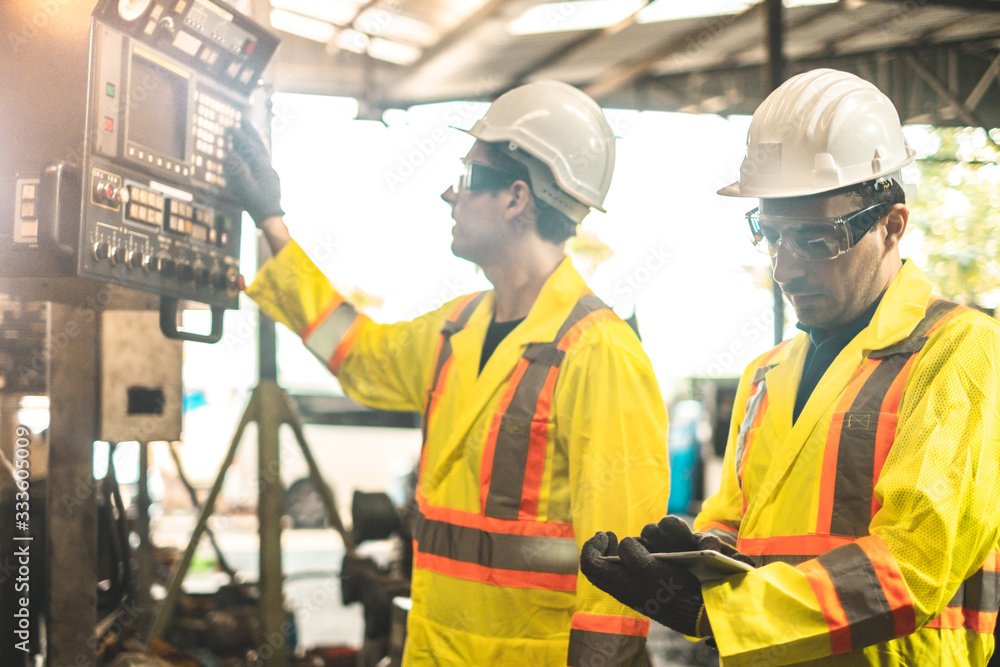 Industrial Engineers in Hard Hats.Work at the Heavy Industry Manufacturing Factory.industrial worker indoors in factory. man working in an industrial factory.Safty first concept. Industrial Engineers in Hard Hats.Work at the Heavy Industry Manufacturing Factory.industrial worker indoors in factory. man working in an industrial factory.Safty first concept.