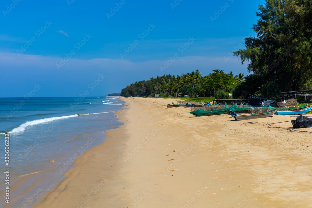 A local fishing village and clean beach with Casuarina plantation and blue sky as background