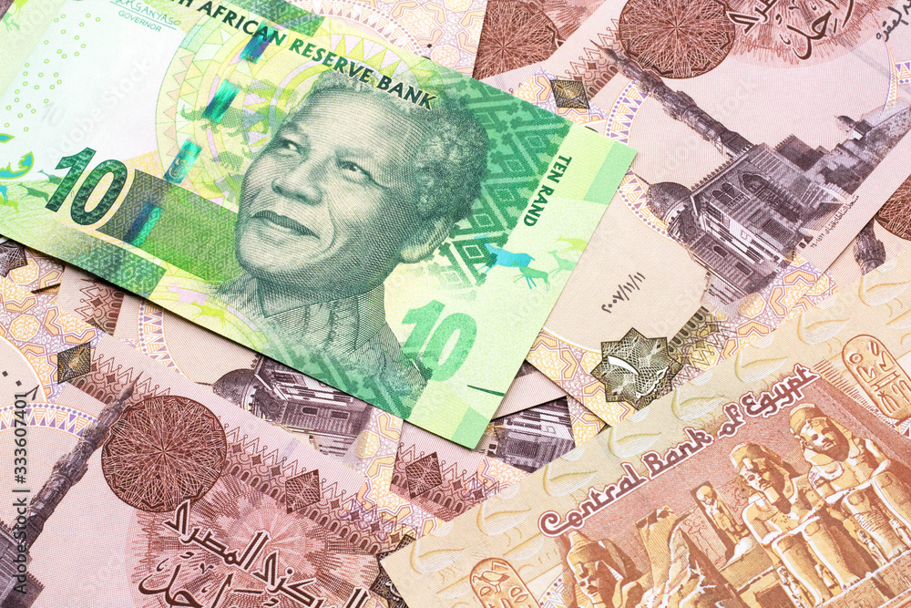 A close up image of a green ten rand bank note from South Africa in macro on a bed of Egyptian one pound bank notes