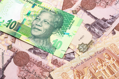 A close up image of a green ten rand bank note from South Africa in macro on a bed of Egyptian one pound bank notes