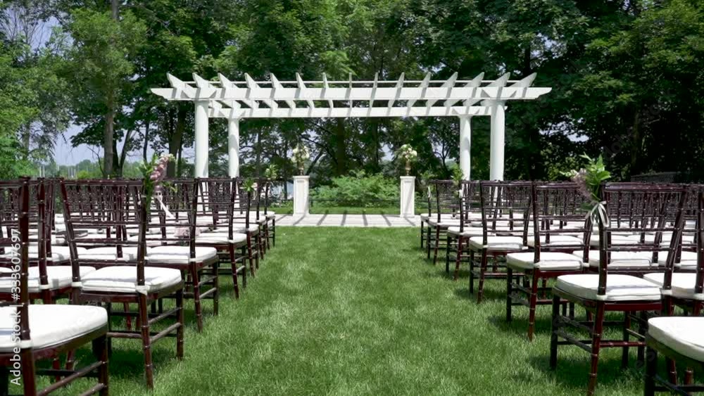 Outdoor wedding aisle ceremony set up no people green trees white chairs sunny day blue sky Outdoor wedding aisle ceremony set up no people green trees white chairs sunny day blue sky