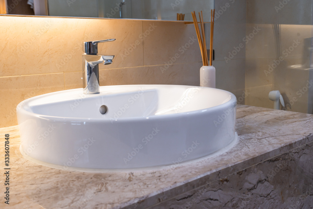 Modern faucet and white ceramic washbasin sink bathroom interior office building or home and living decoration Modern faucet and white ceramic washbasin sink bathroom interior office building or home and living decoration