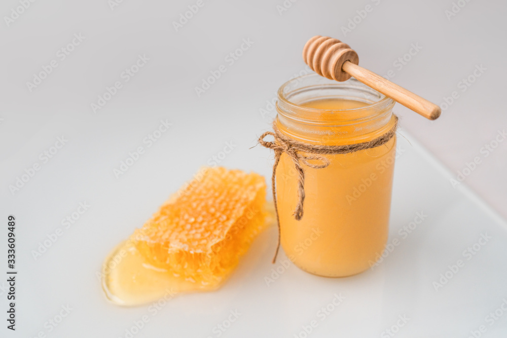 Honey pot with honey dipper and natural honeycomb . Honey pot with honey dipper and natural honeycomb .