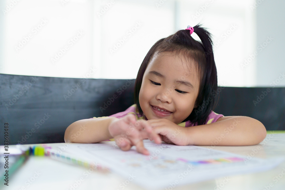 Kindergarten Asian girls doing homework at home with happy face Full of smiles, fun, and enjoyment Kindergarten Asian girls doing homework at home with happy face Full of smiles, fun, and enjoyment