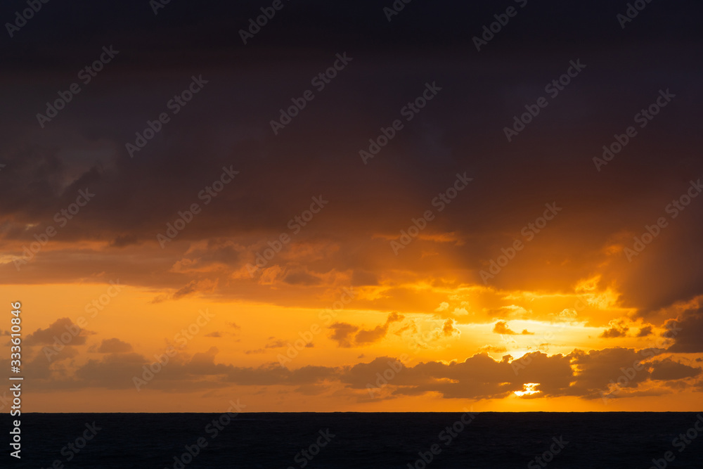 Orange sky view during sunrise with clouds around.