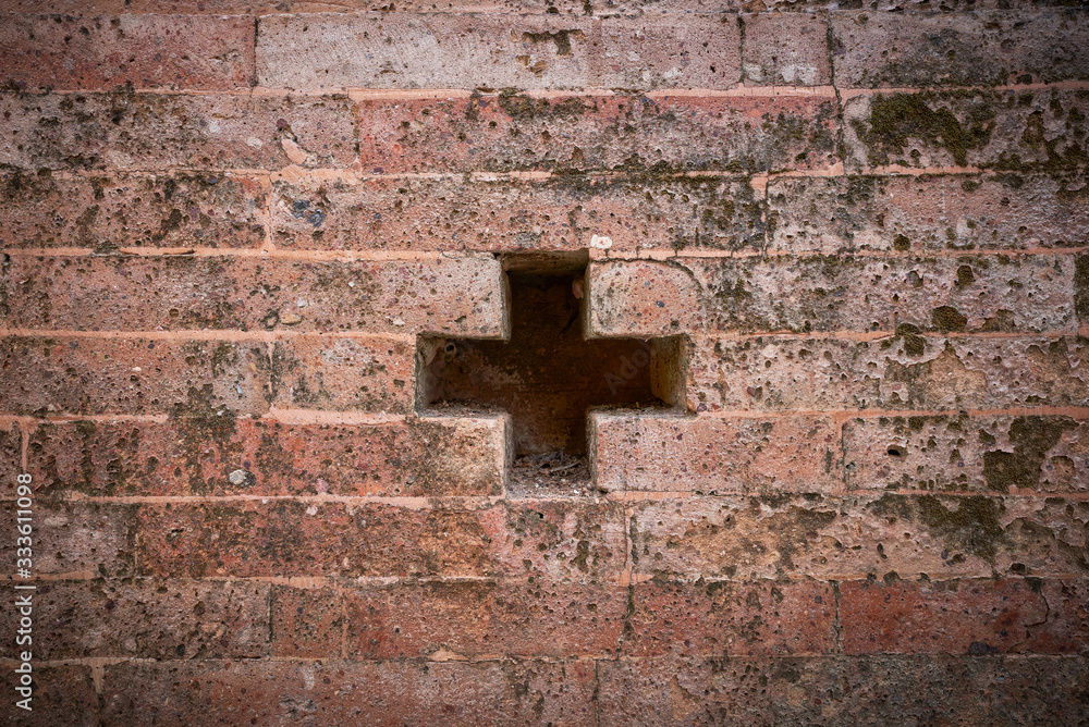 old red brick wall background with cross hold sign