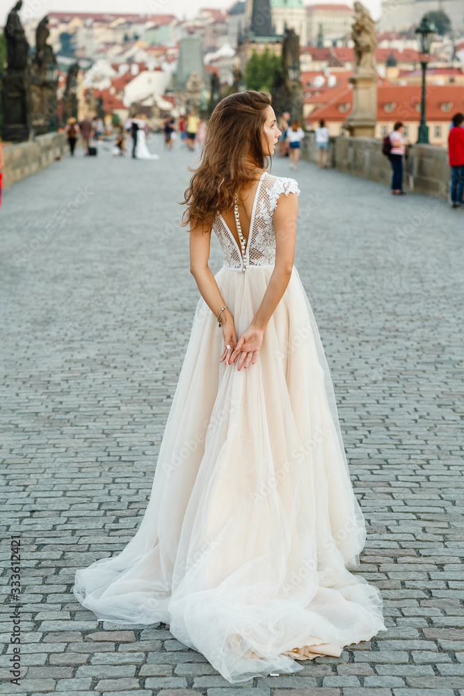 Young bride poses on Charles Bridge. Bride in prague Young bride poses on Charles Bridge. Bride in prague