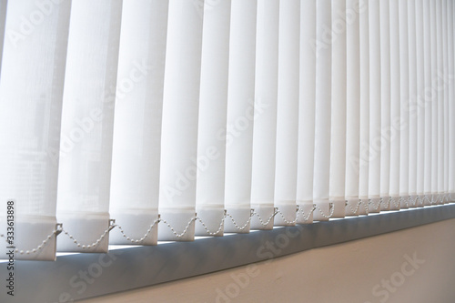 White vertical blind, Modern office sun blinds, Concept image for sustainable design and energy saving.