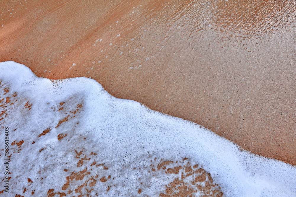 Fototapeta premium Wave On Sandy Beach. Background. Splash of waves on the sandy beach. foam, surf, waves.