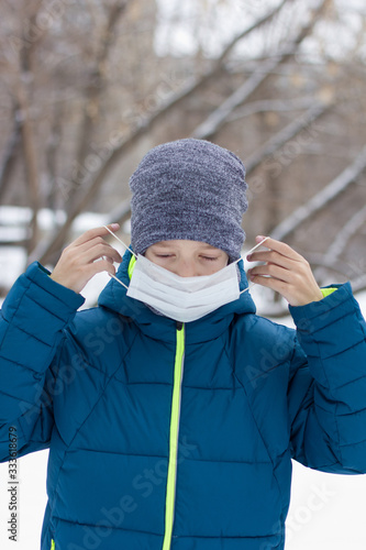 The danger of coronavirus. A boy on a walk walks in a medical mask on his face