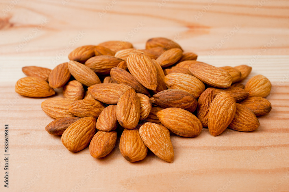 Almonds nuts shot large on a wooden background. Background for healthy eating and vegetarianism. Almonds nuts shot large on a wooden background. Background for healthy eating and vegetarianism.