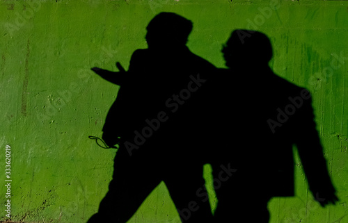 silhouette of two men woman on green background