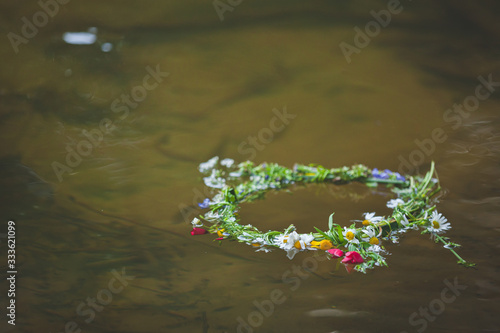 A beautiful wreath of summer wildflowers floats along the river. Festivities. Summer time