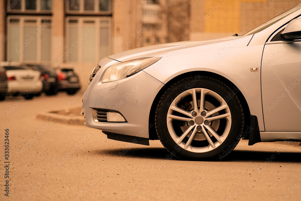 Car in the Parking lot. Close-up of the front of the car. Abstract street background. Street style. The background of nature. Car in the Parking lot. Close-up of the front of the car. Abstract street background. Street style. The background of nature.
