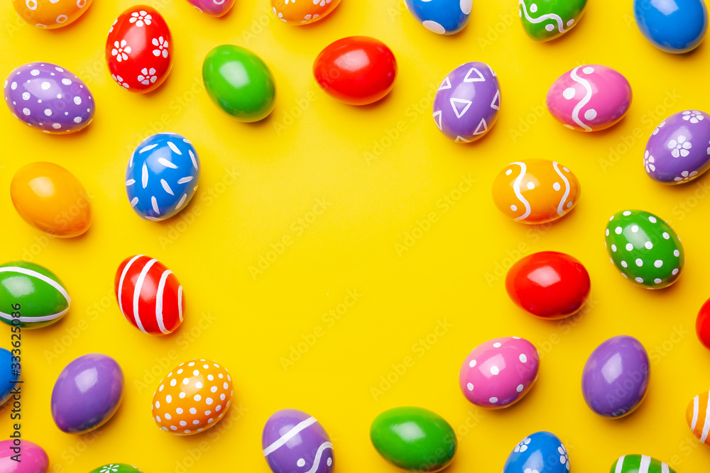 Flat lay composition with Easter eggs on color background. Frame made of decorated eggs. Top view with place for text