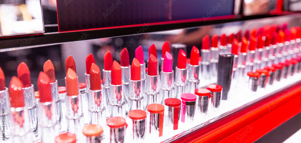 Lipstick testers in a shop window. Assortment of different colors. Panorama format.
