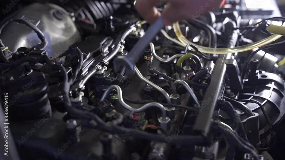 A man repairs a car in a service station - engine diagnostics A man repairs a car in a service station - engine diagnostics