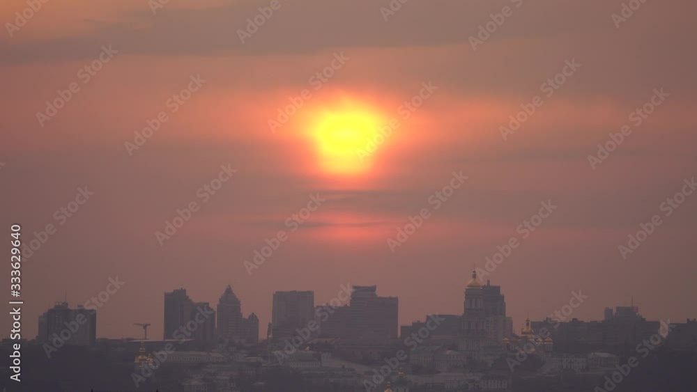 Silhouette of the City Against dramatic Sky During Sunset with sun close up Silhouette of the City Against dramatic Sky During Sunset with sun close up