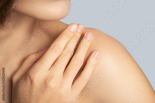 Close up of tender woman that touching her shoulder