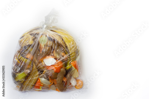 Food waste carrots, bananas, potatoes, oranges, onions, eggshells in a transparent bag on a white background.Top view. Flat lay. Copy space. Waste for recycling.