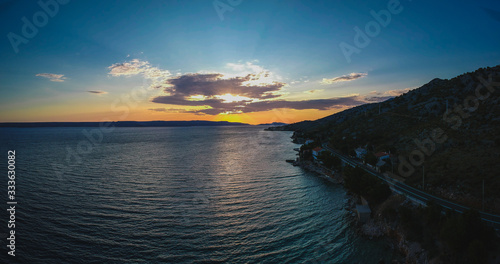Evening drone panorama of croatian coast close to Karlobag with amazing view towards island of Pag and Rab.Sun just about to set behind clouds to the sea.