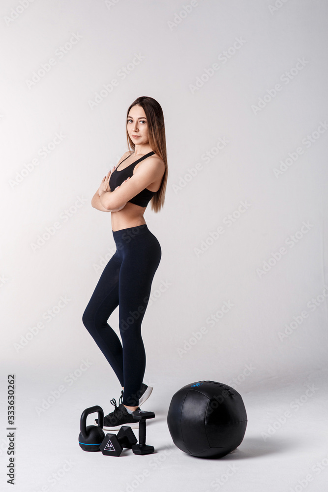 Young fitness model on a white background. with sports equipment Young fitness model on a white background. with sports equipment