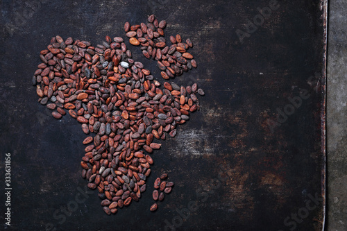 Africa with cocoa beans. Background from cocoa beans on a dark background.