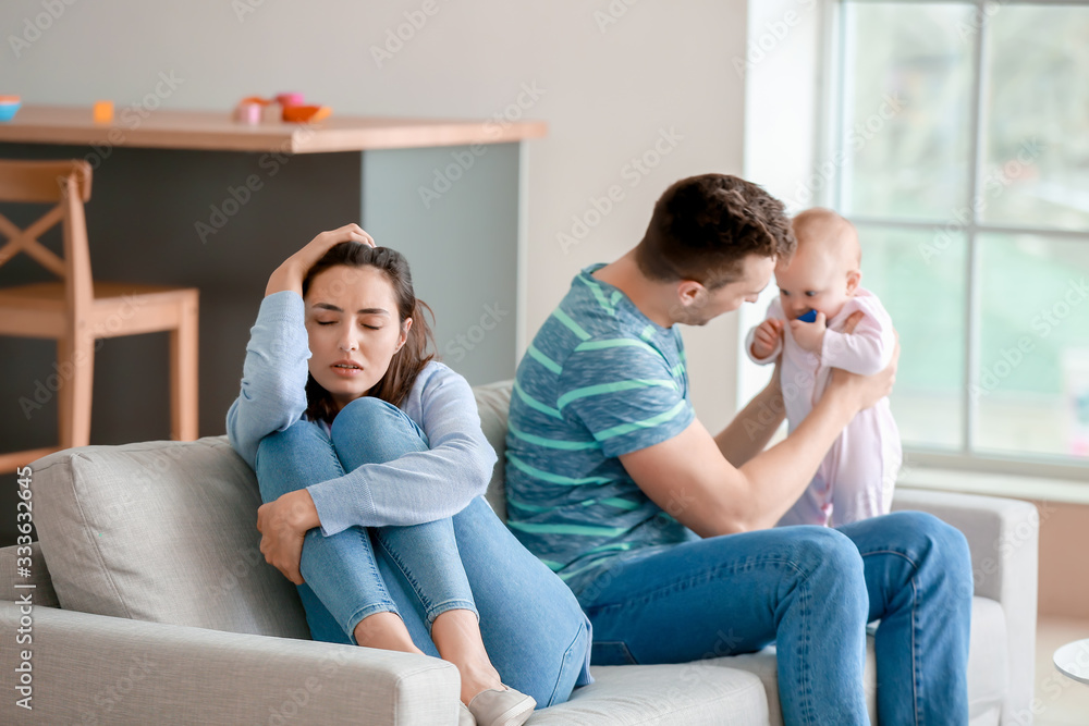 Happy father with his baby and wife suffering from postnatal depression at home Happy father with his baby and wife suffering from postnatal depression at home