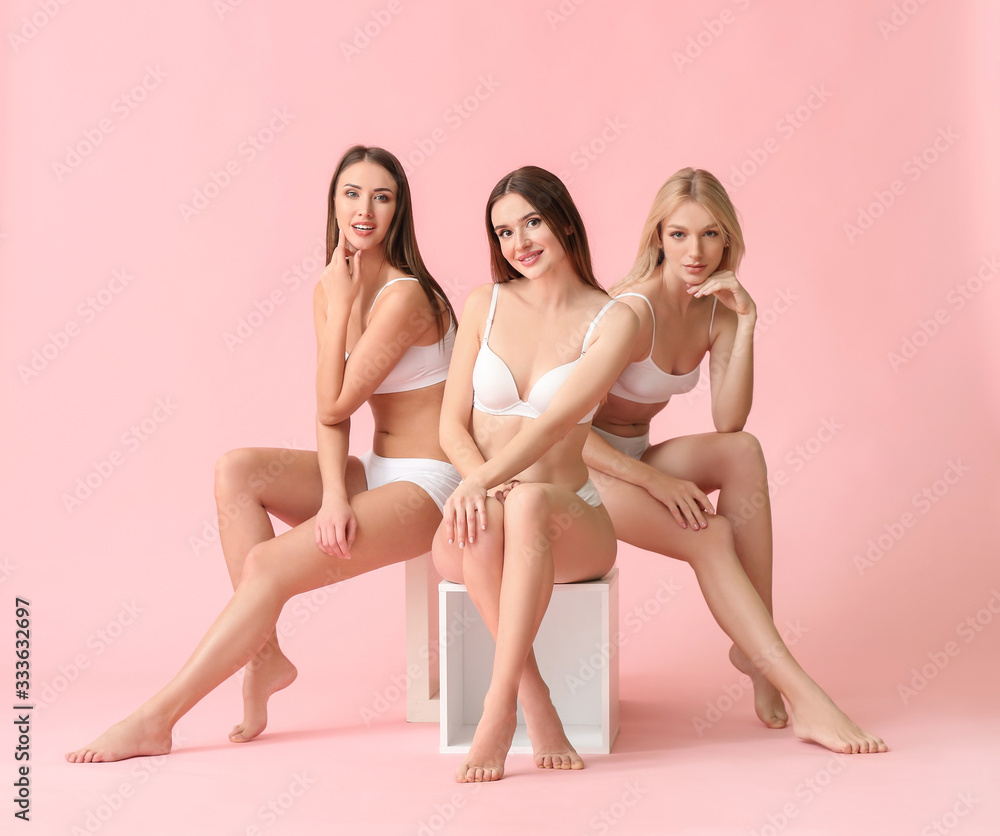 Beautiful young women in underwear on color background