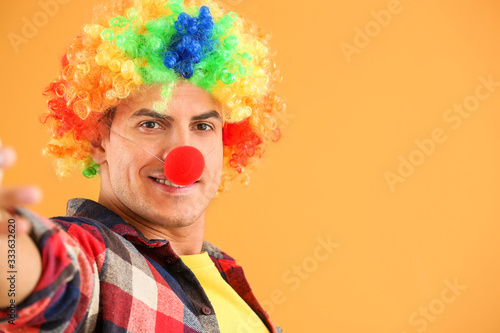Man in funny disguise taking selfie on color background. April fools' day celebration