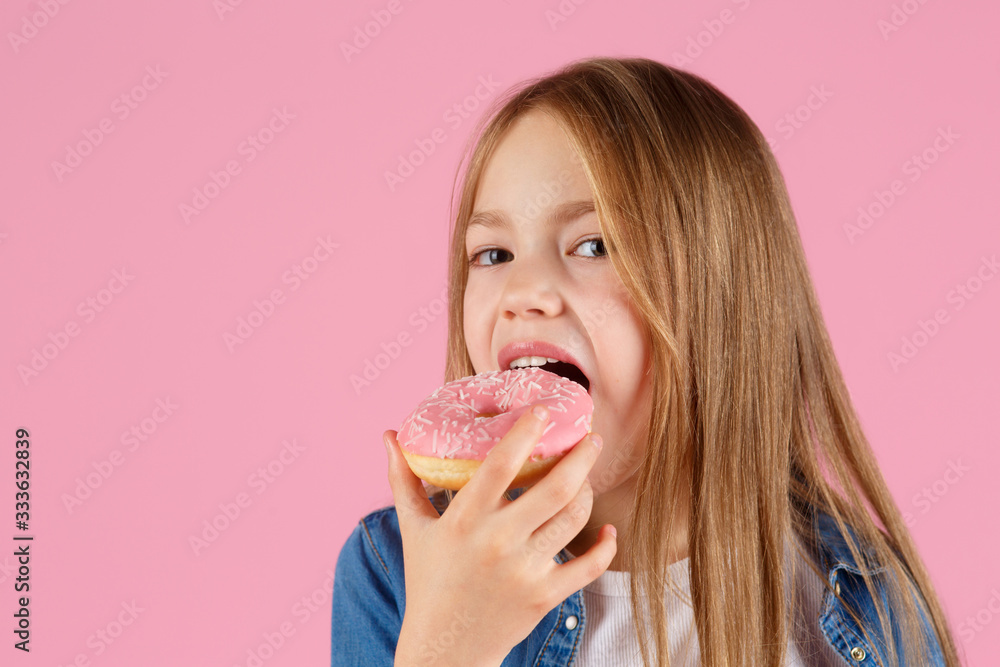 girl playing with a donut on a pink background. girl playing with a donut on a pink background.