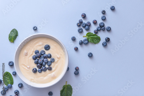 Bowl with tasty yogurt and berries on color background