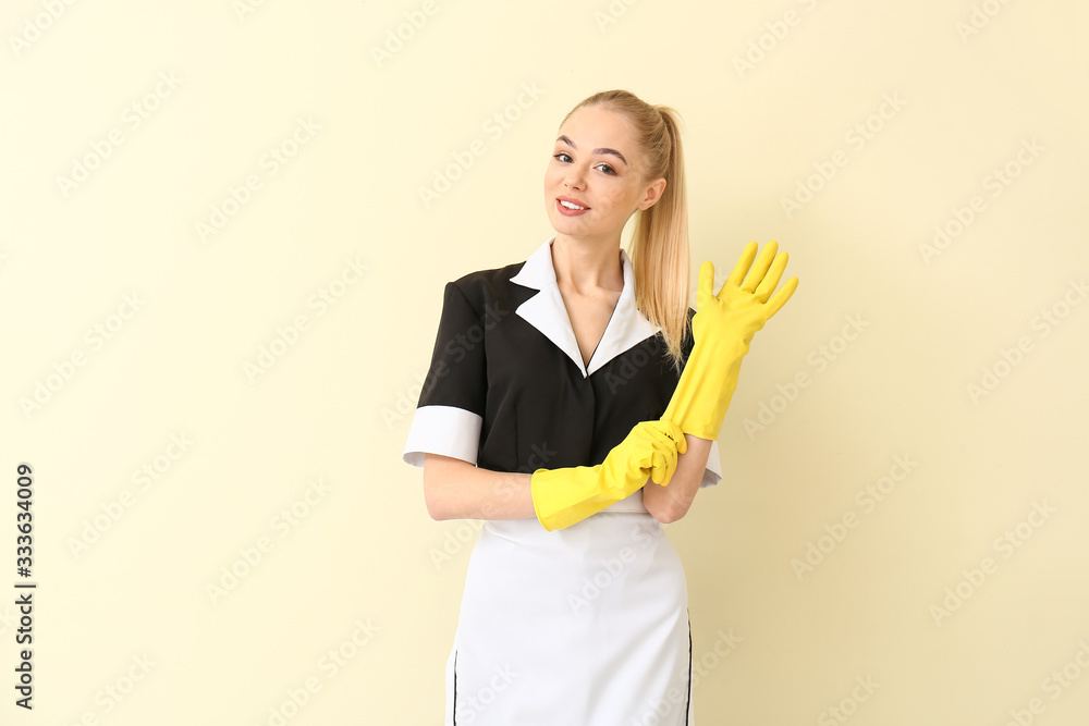 Beautiful young chambermaid on light background Beautiful young chambermaid on light background