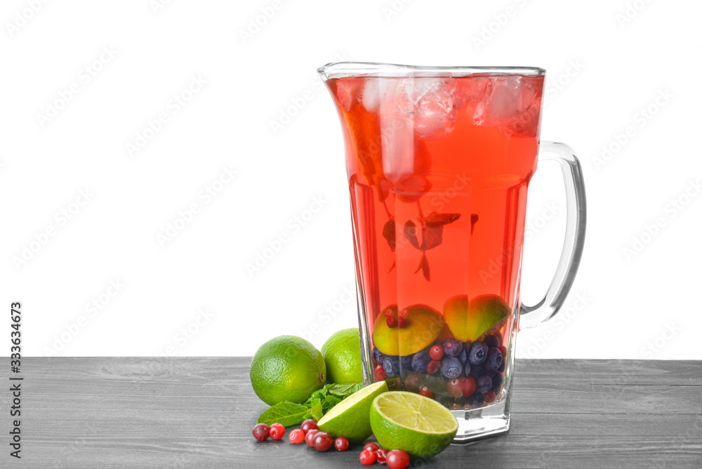 Jug of tasty cold tea on table against white background Jug of tasty cold tea on table against white background