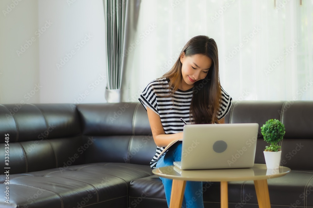 Portrait beautiful young asian woman using laptop or computer noterbook on sofa with concept work from home Portrait beautiful young asian woman using laptop or computer noterbook on sofa with concept work from home
