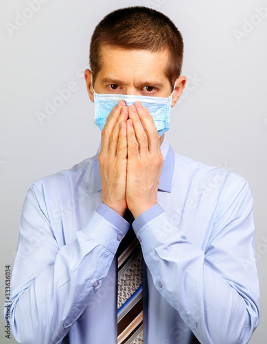 A business man in a mask grabbed his face with his hands